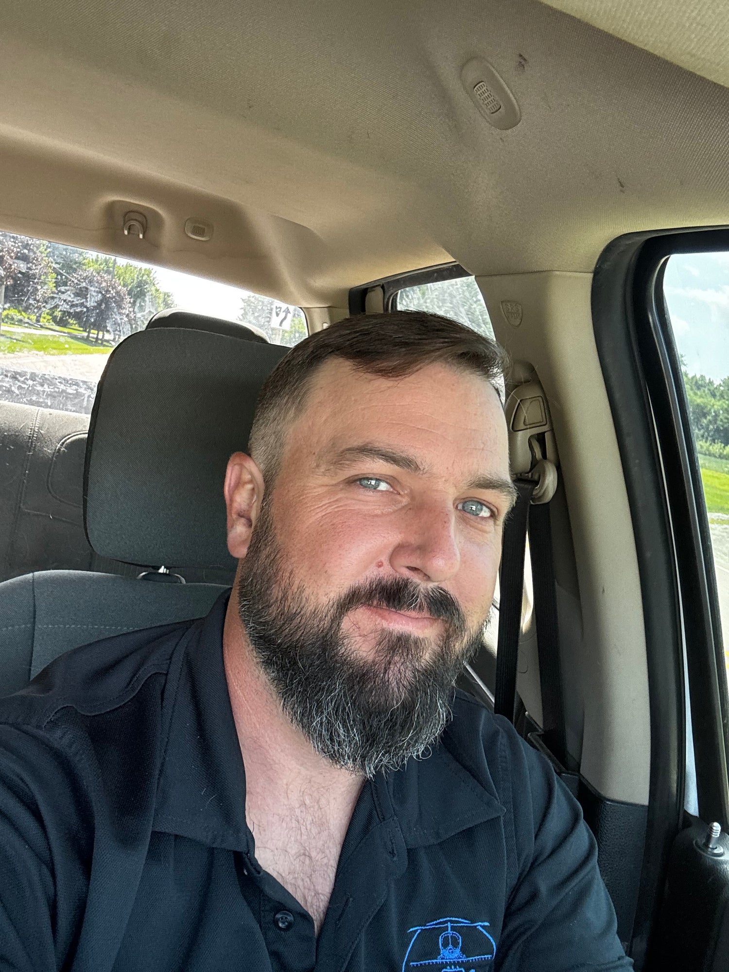 Erik Simmons, owner and pilot at Premium Ag Services, in a Premium Ag Services shirt in the cab of his truck in Newark, Illinois