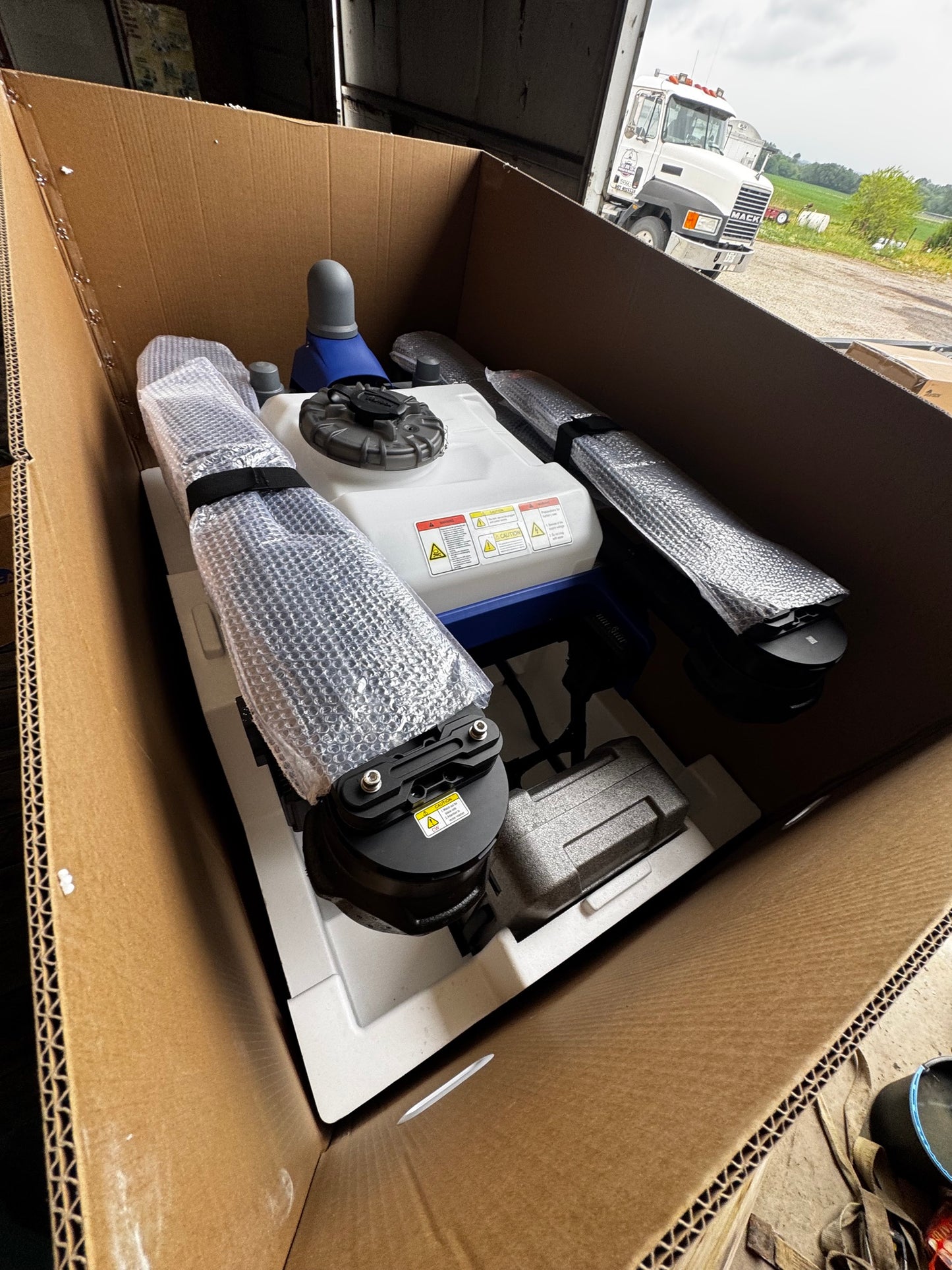 EAVision J150 spray drone inside its shipping crate, arms bubble wrapped and the aircraft seated in moulded foam packaging